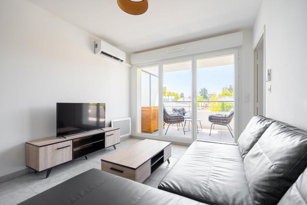 un salon avec un canapé et une télévision à écran plat dans l'établissement T2 Entre la plage et le Vélodrome - Clim/Parking, à Marseille