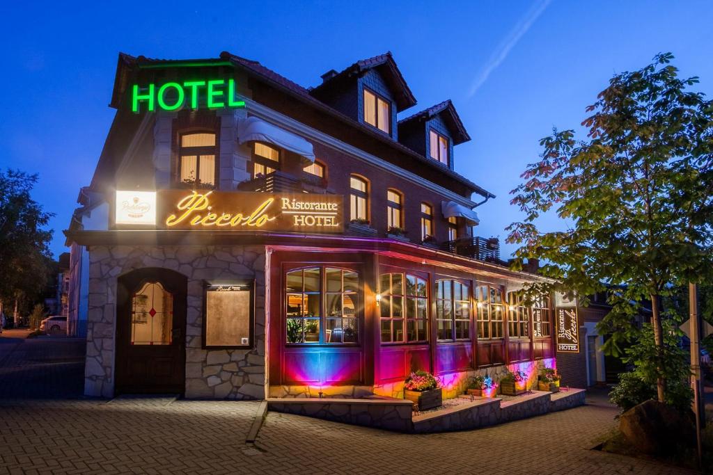 a hotel with a neon sign in front of it at Hotel und Restaurant Piccolo in Thale