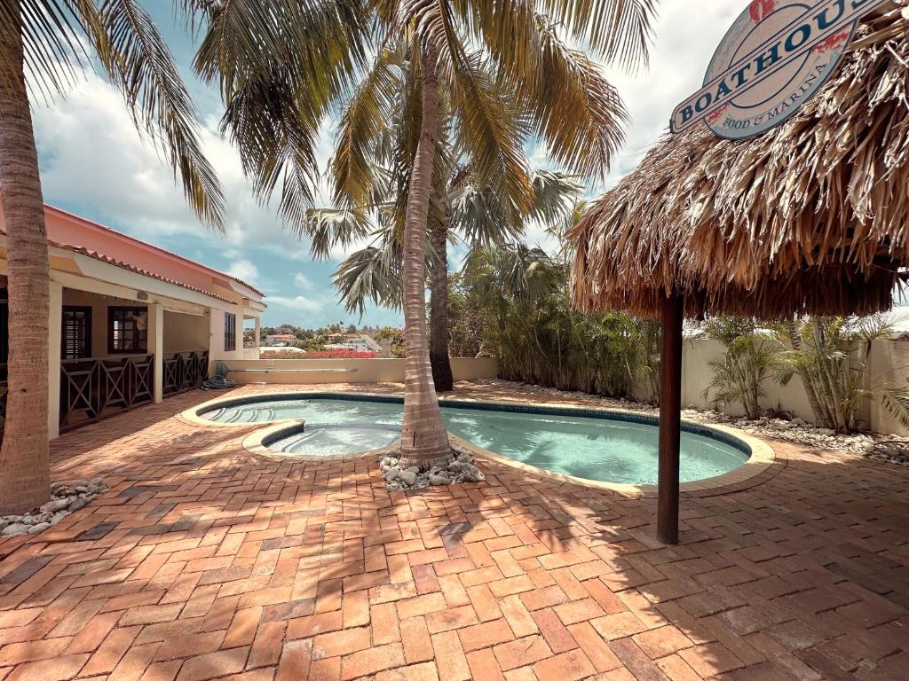 ein Pool mit zwei Palmen neben einem Gebäude in der Unterkunft Sylvie Resort Curaçao in Willemstad
