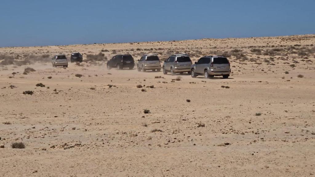 a group of cars parked in the desert at Excursion dakhla tour in Dakhla