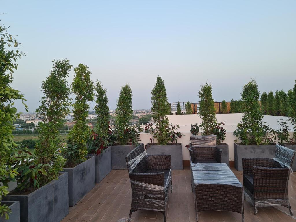 a patio with chairs and tables and potted plants at 1 Bed Modern Apartment, Pool, Gym, Cinema in Lahore