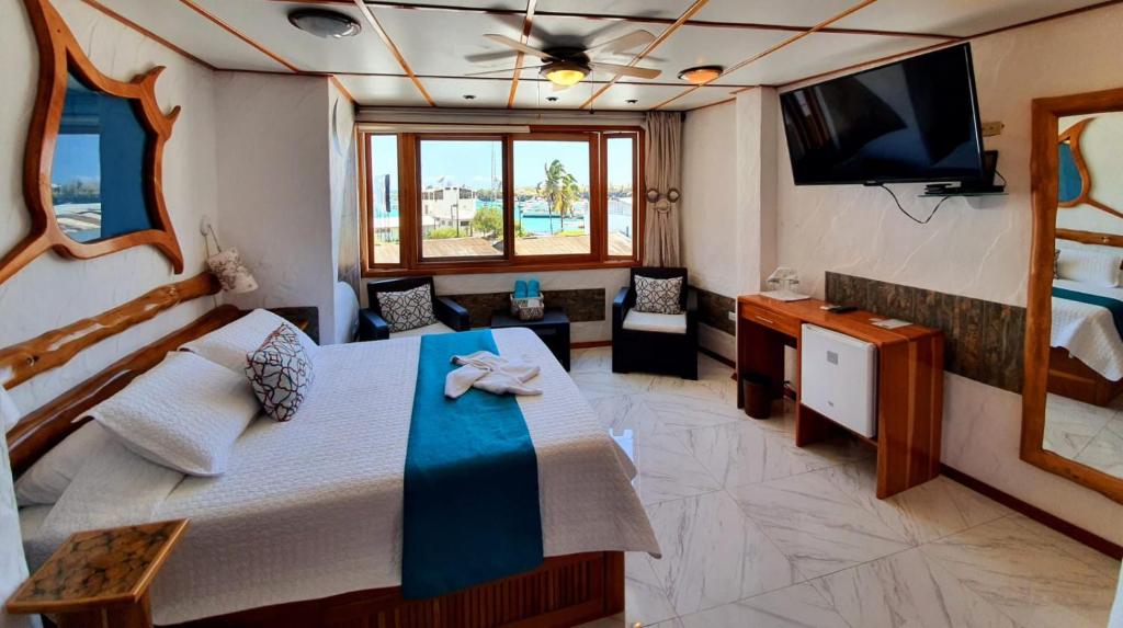 1 dormitorio con 1 cama grande y TV en Casa Ocean Pier en Puerto Ayora