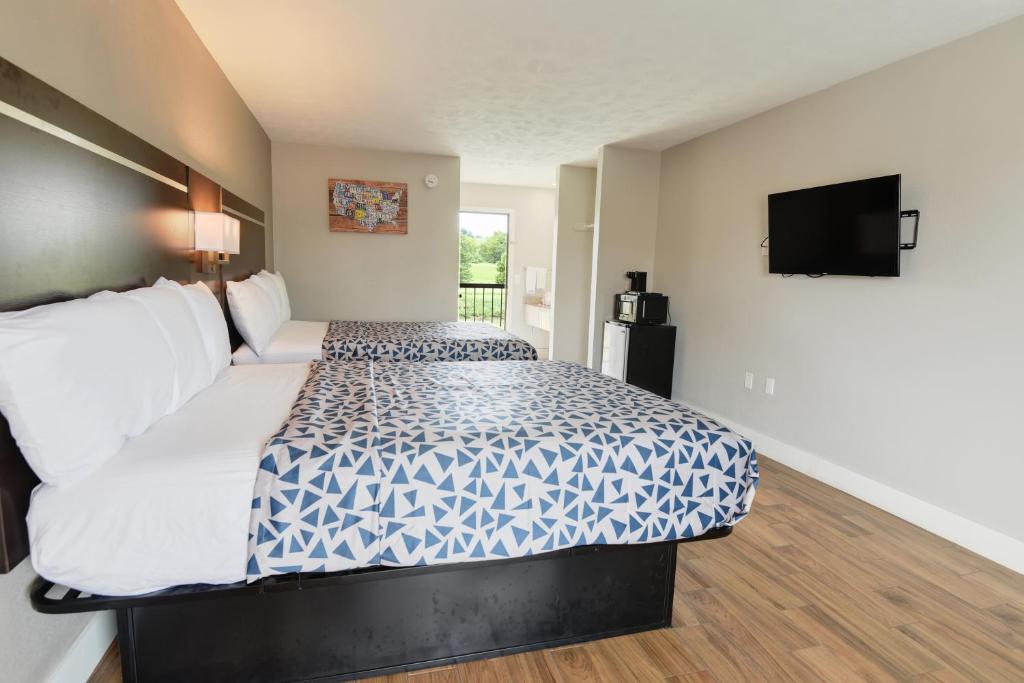 a bedroom with a large bed with a tv on the wall at Econo Lodge on the River Sevierville-Pigeon Forge in Sevierville