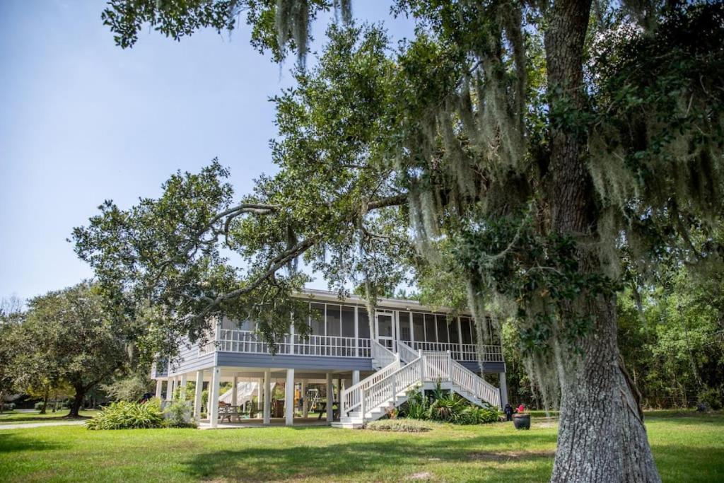 a large house with a tree in front of it at Cypress Landing in Pass Christian