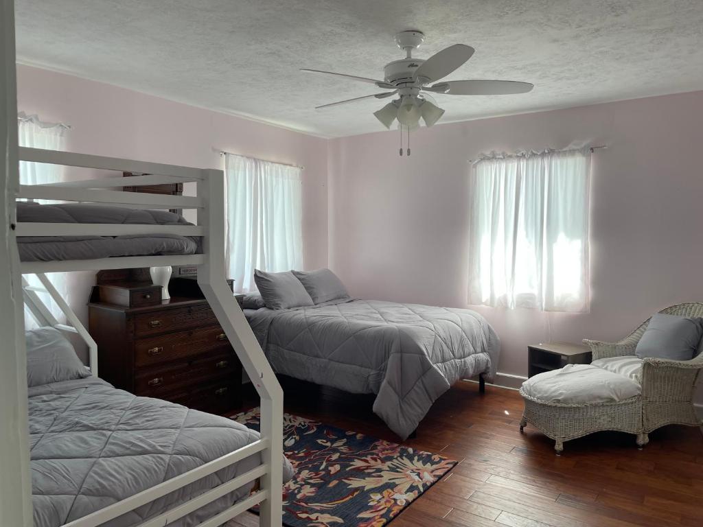 a bedroom with two bunk beds and a ceiling fan at The Painted Lady, a spacious renovated 4BR Victorian in St. Augustine