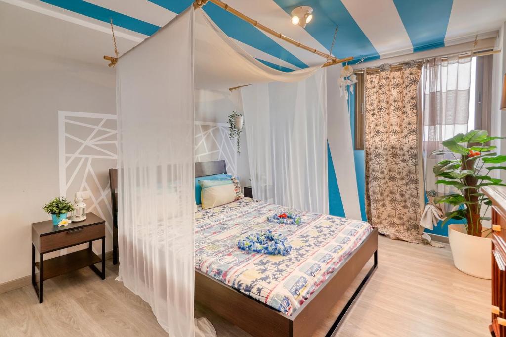 Aloha Home في لوس أبريغوس: غرفة نوم بسرير مع مظلة