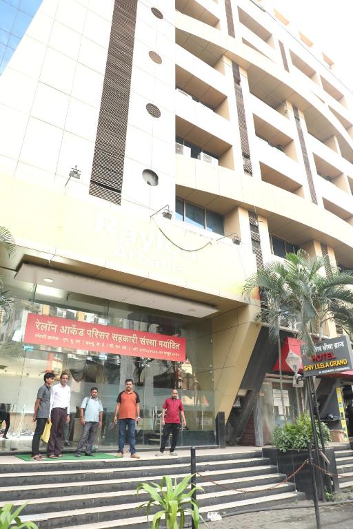 grupa ludzi stojących przed budynkiem w obiekcie Hotel Shiv Leela Grand w Bombaju