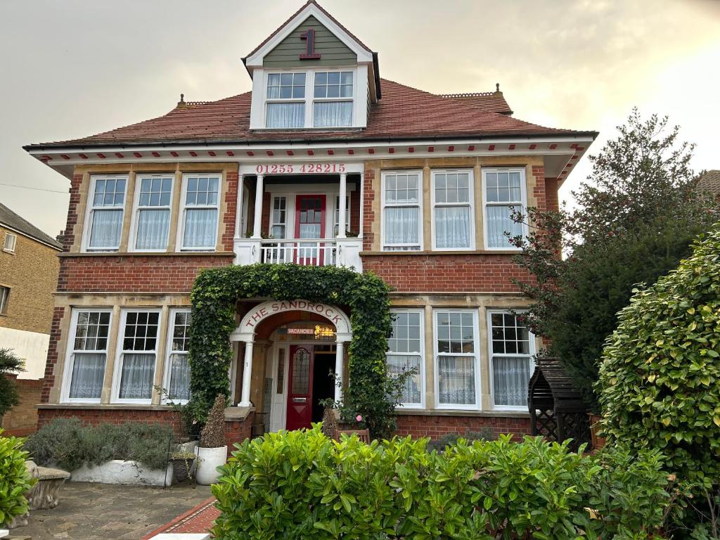 a large brick house with a red door at The Sandrock in Clacton-on-Sea
