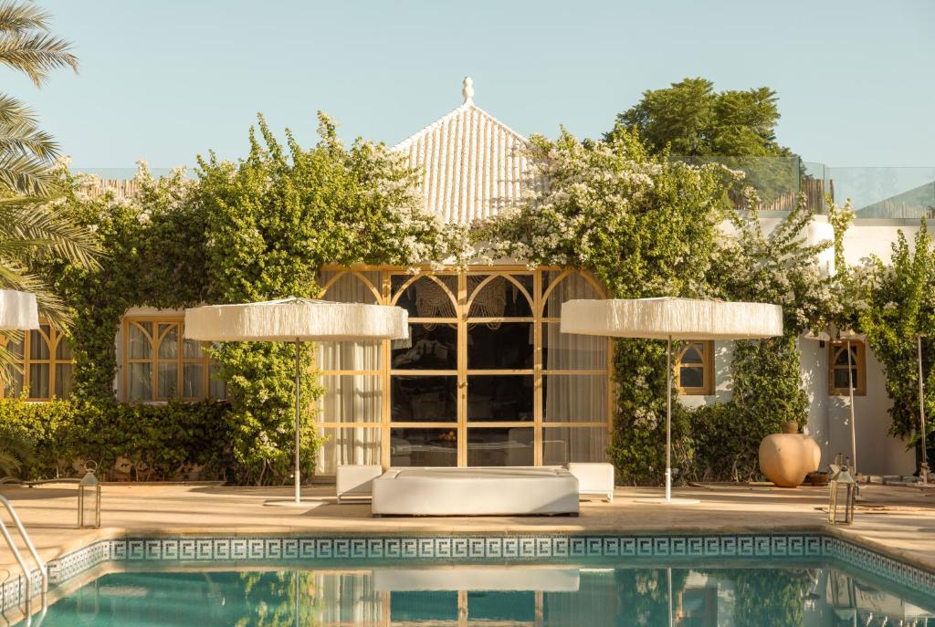 a swimming pool in front of a house with a building at Les Palmiers Boutique Hôtel & Spa in Marrakech