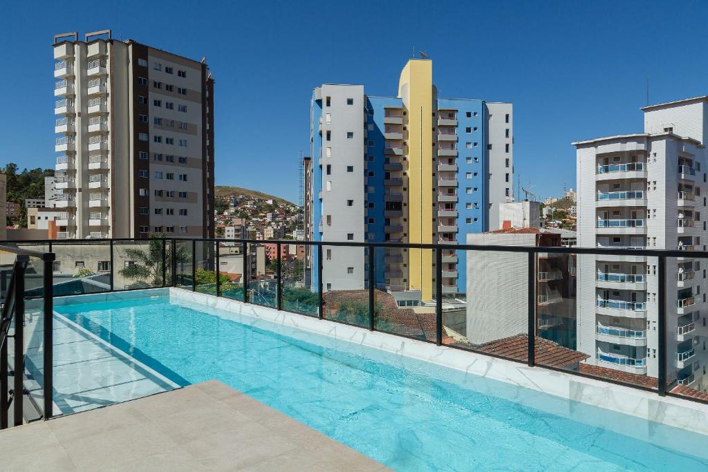 uma piscina numa varanda com edifícios em Lindo e aconchegante apto proximo ao centro PGO309 em Poços de Caldas