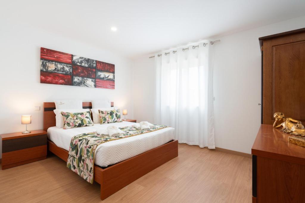 a white bedroom with a bed and a window at Casa Petisqueira 88-Paredes-Oporto in Rebordosa