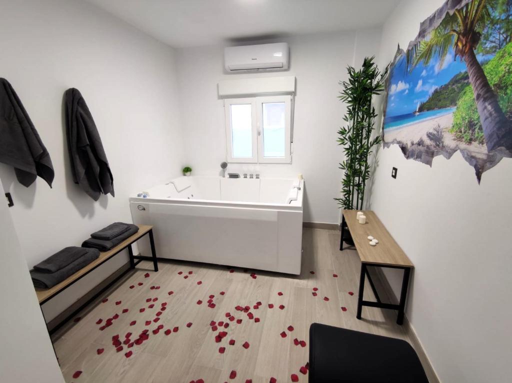 baño con bañera blanca y hojas rojas en el suelo en apartamento con jacuzzi, El Rincón de Ayud, en Calatayud