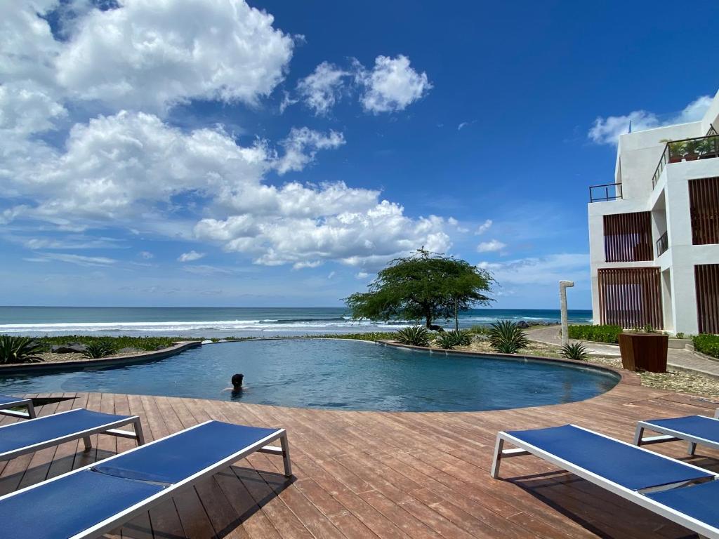 a swimming pool with the ocean in the background at Hacienda Iguana beach front Penthouse with swimming pools and ocean view in Tola
