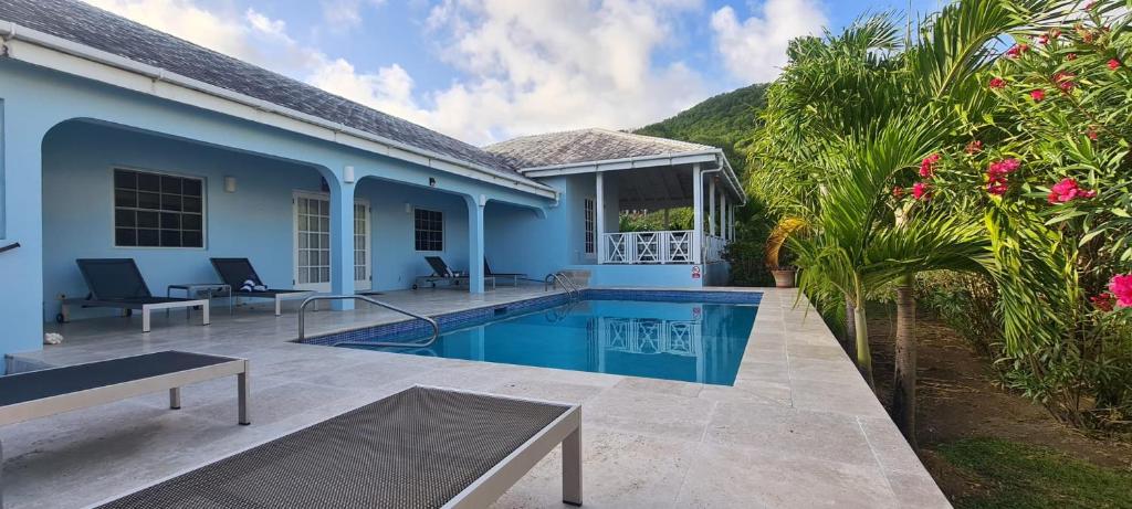 a villa with a swimming pool and a house at Luxury secluded villa with private pool sleeps six in Jolly Harbour