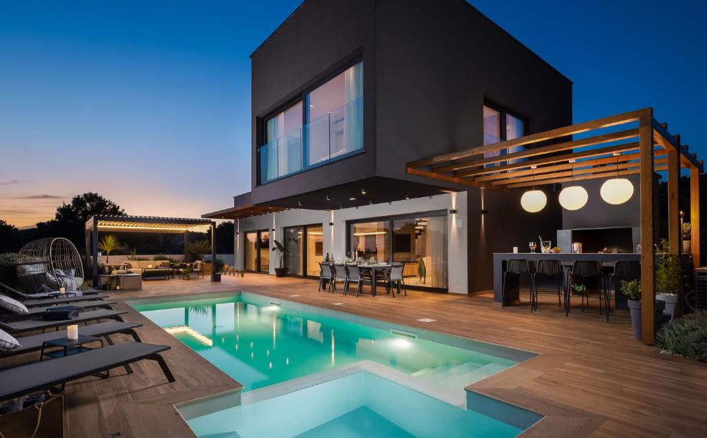 ein Haus mit Pool davor in der Unterkunft Luxury villa Indigo with swimming pool, sauna and jacuzzi in Kanica - Rogoznica in Sevid