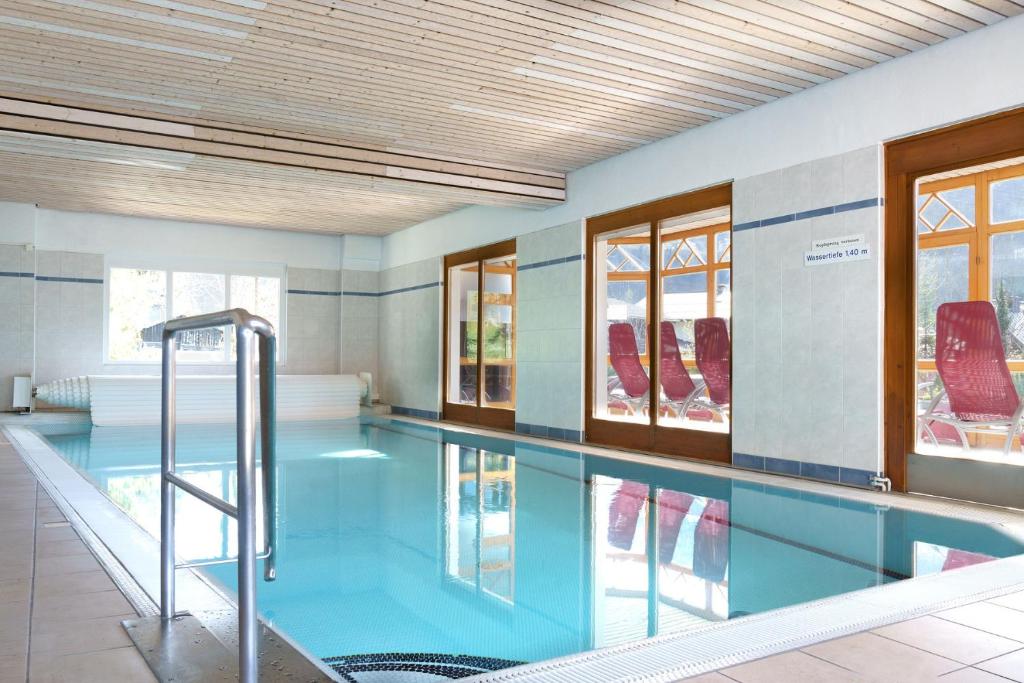 a swimming pool with blue water in a building at Ferienwohnungen Badbruckerweg- Bad Gastein in Bad Gastein