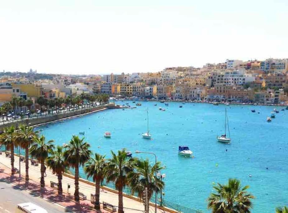 a large body of water with boats and palm trees at Cozy appartament sea view in Marsaskala