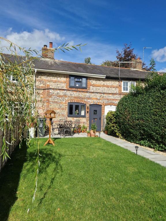 a brick house with a lawn in front of it at Idyllic period cottage, Ramsbury, Nr Marlborough in Ramsbury