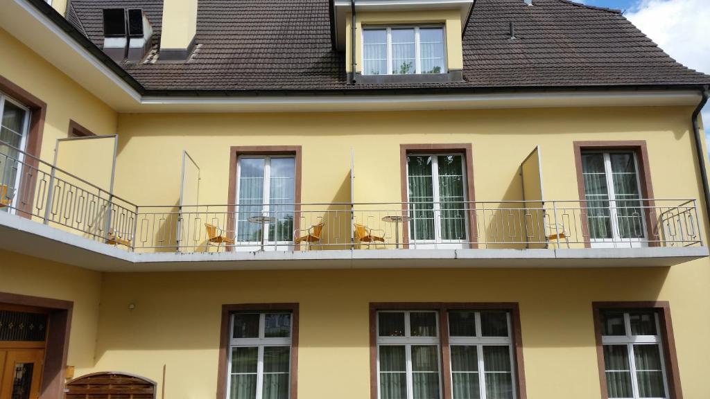 a yellow house with a balcony at Hotel Rössli in Basel
