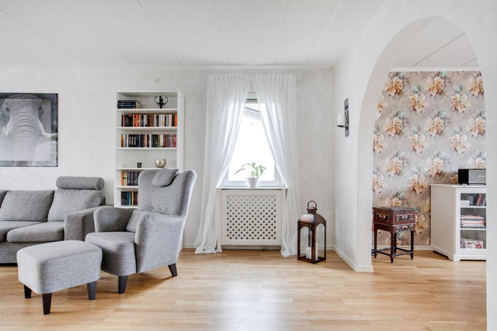 a living room with a couch and a chair and a window at very comfortable room in a unique villa in Gävle