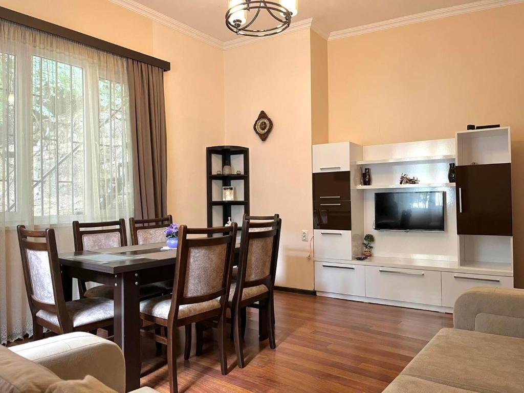 a living room with a dining table and a television at Apartment Amaghleba in Tbilisi City