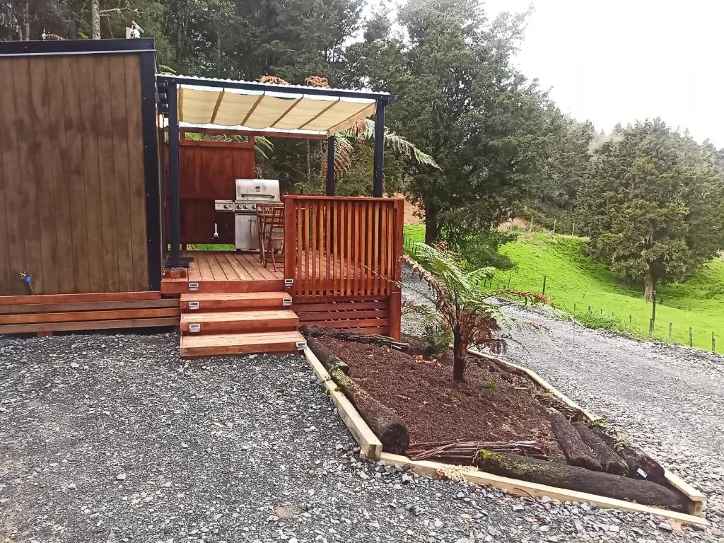 a backyard with a wooden deck and a grill at Bush Cabin Stunning views in Taumarunui