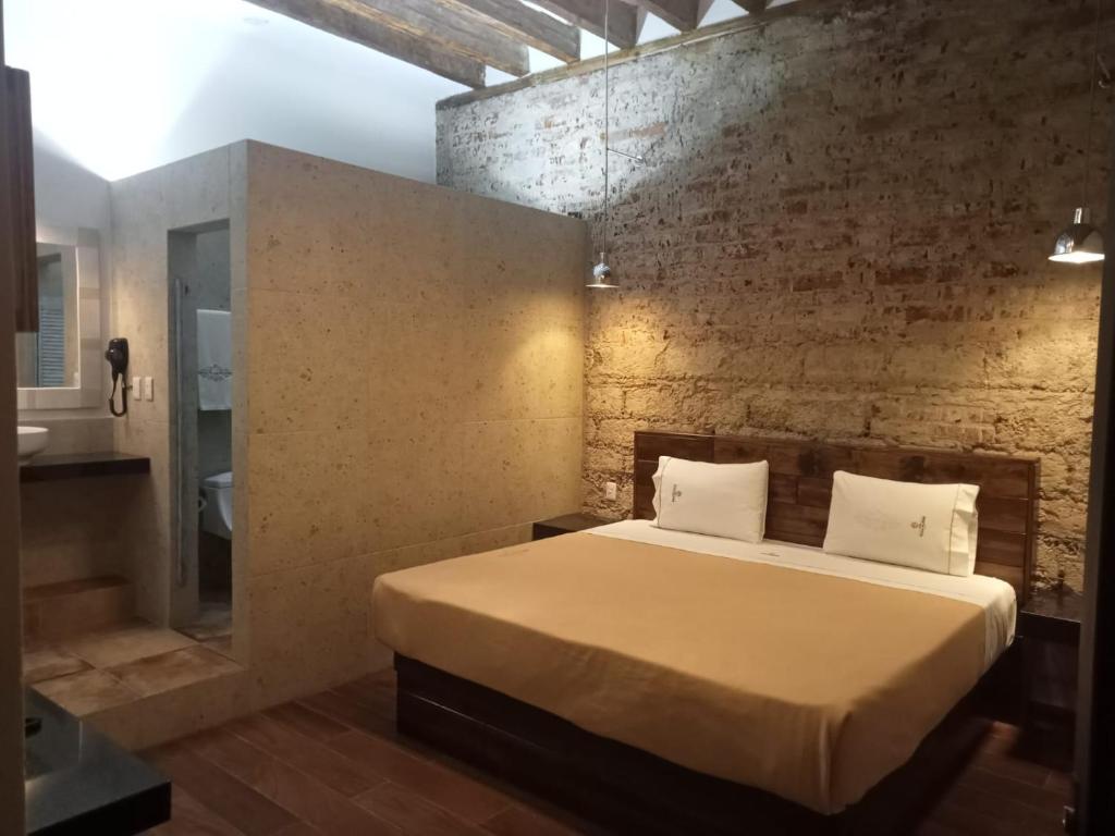 墨西哥城的住宿－Hotel Sonno Plaza Allende，一间卧室设有一张床和砖墙