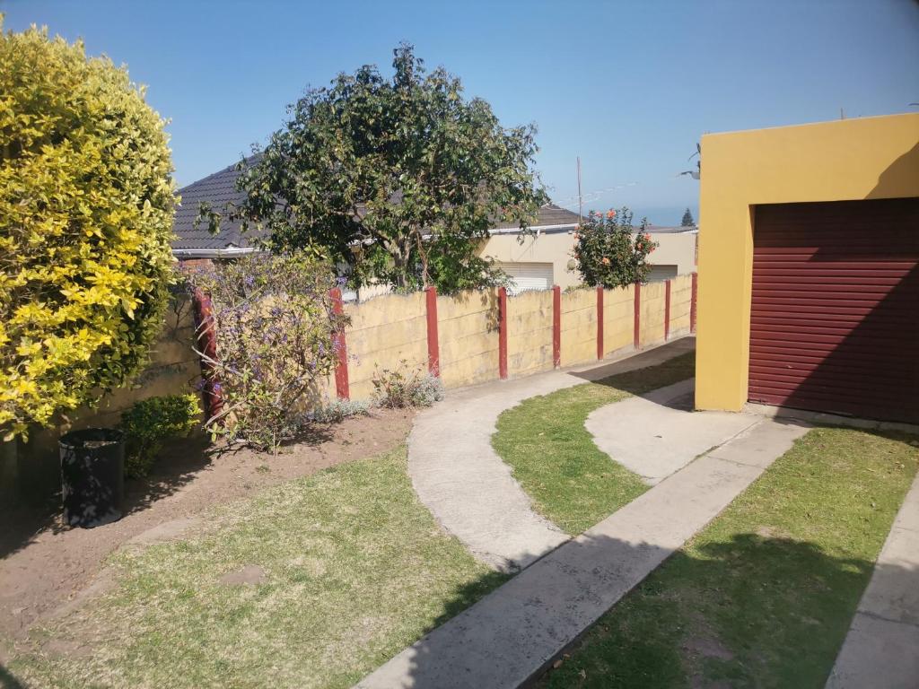 a driveway leading to a house with a red and yellow garage at Izibusiso Guest room in East London