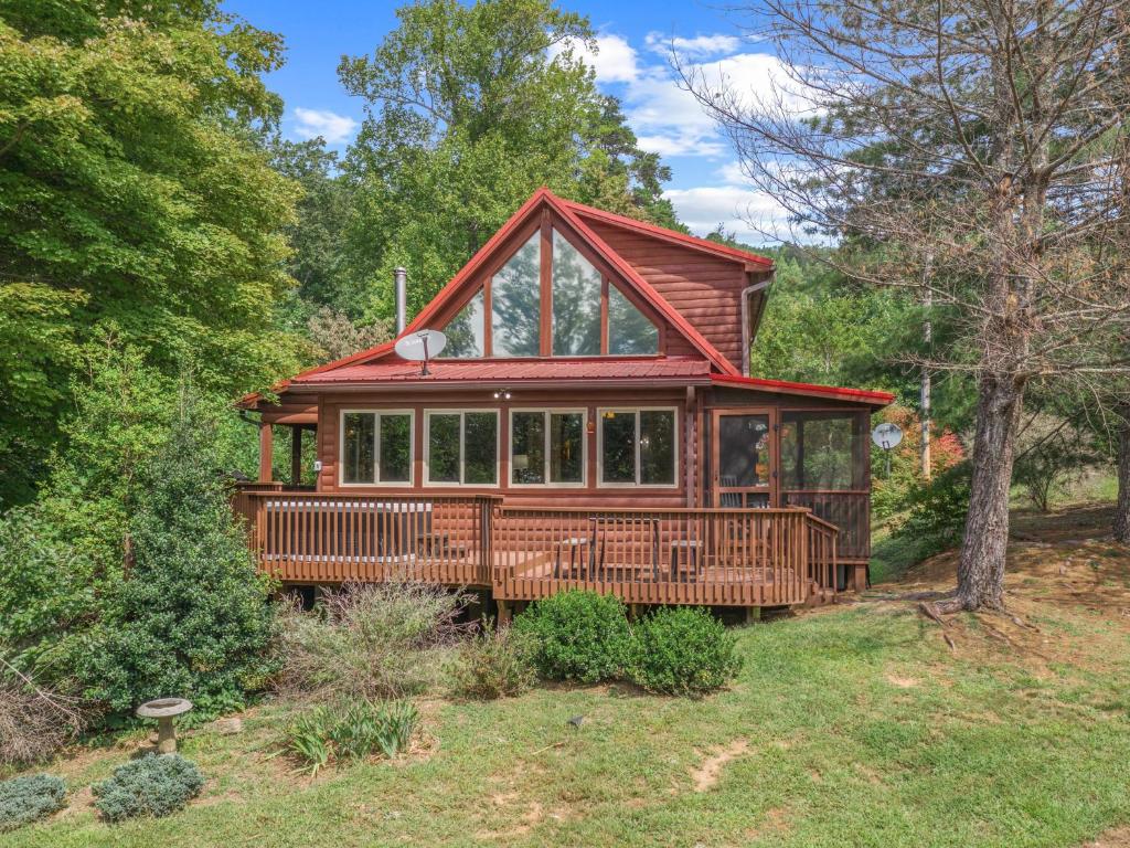 une grande maison entourée d'une terrasse couverte dans les bois dans l'établissement Luxury Cabin 45 Min to Asheville Hot Tub & Fire pit, à Marion