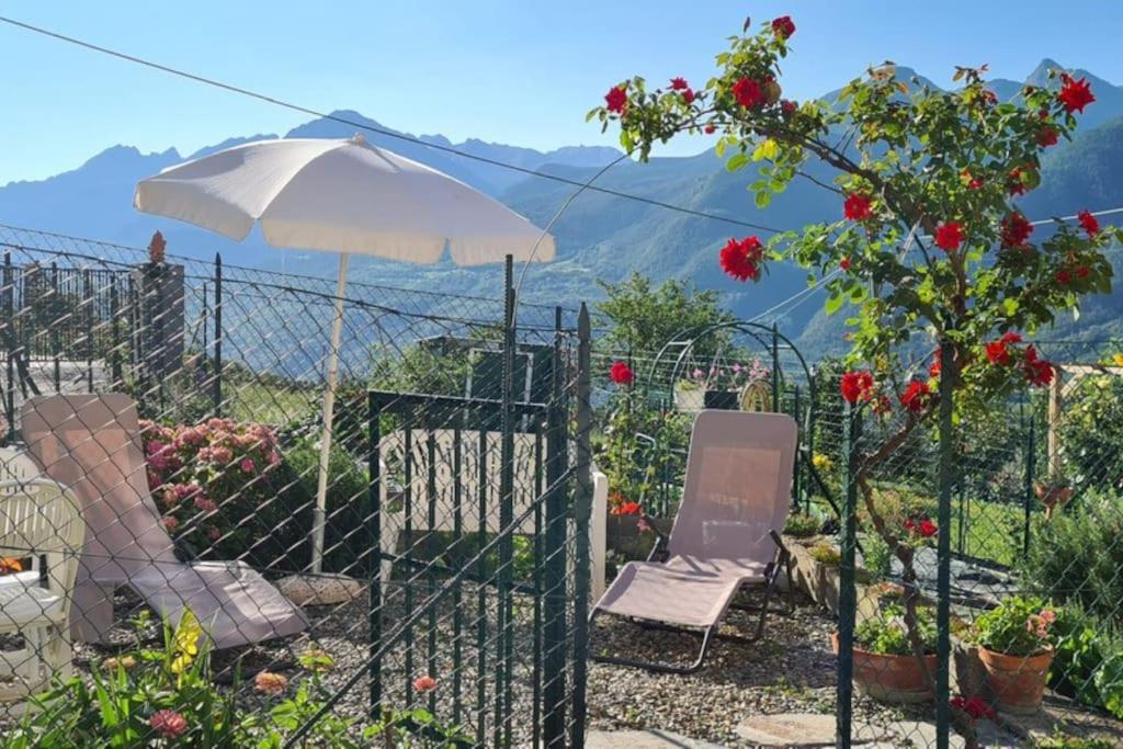a fence with two chairs and an umbrella at Le petit coin de Lea in Quart