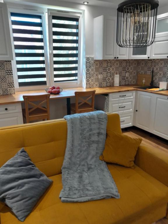 a kitchen with a couch with a blanket on it at Apartament "Konie i anioły" in Boguszów-Gorce