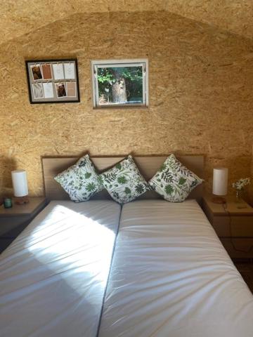 - un lit dans une chambre avec 2 photos sur le mur dans l'établissement Blockhütte 2, à Dötlingen