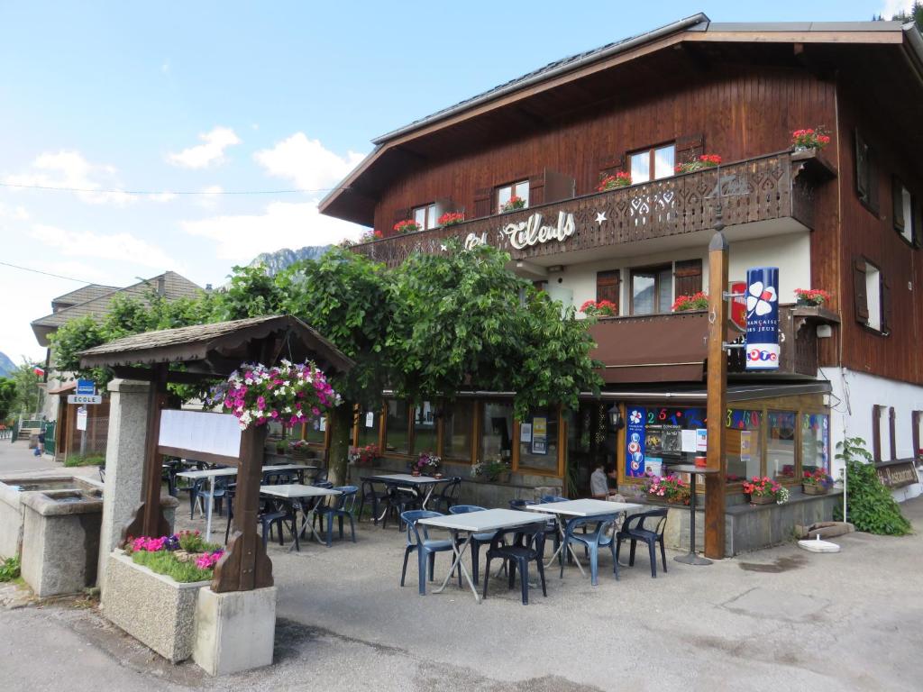 un restaurante con mesas y sillas frente a un edificio en Les Tilleuls, en Le Biot
