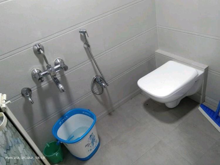 a bathroom with a toilet and a trash can at Marol dormitory in Mumbai