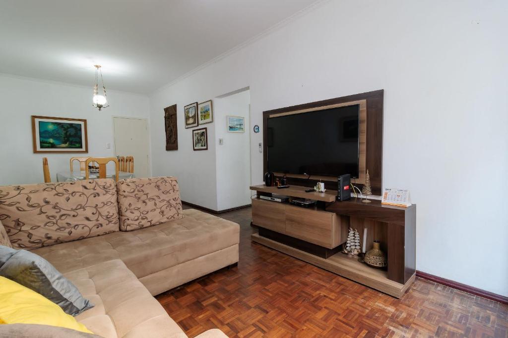 uma sala de estar com um sofá e uma televisão de ecrã plano em SDF - Apartamentos lindos em Floripa-SC em Florianópolis