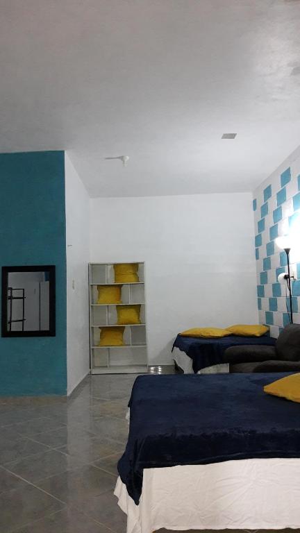 um quarto com duas camas e uma prateleira com almofadas amarelas em Departamento en la 43 em Oxkutzcab