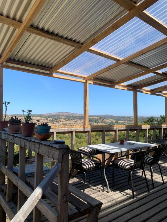 a patio with a table and chairs on a deck at Hostal El Boldal in La Estrella