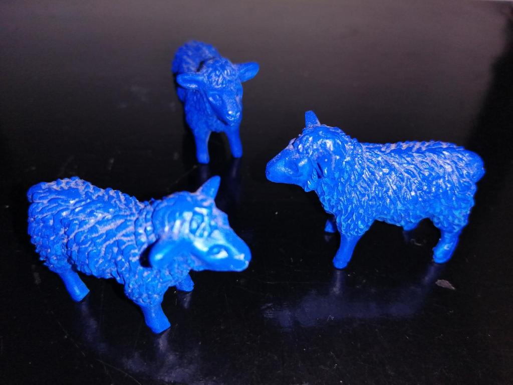 tres vacas de plástico azules sentadas en una mesa en Chambre d'hôtes Les moutons bleus, en Le Tronquay