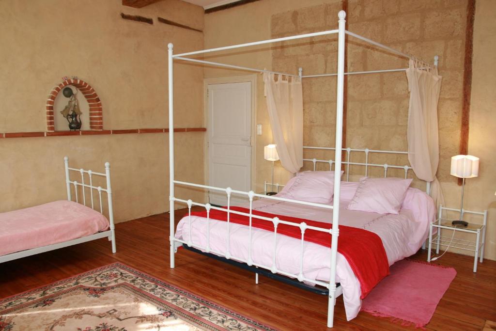 a bedroom with a four poster bed and a rug at Un Coin de Paradis in Cologne