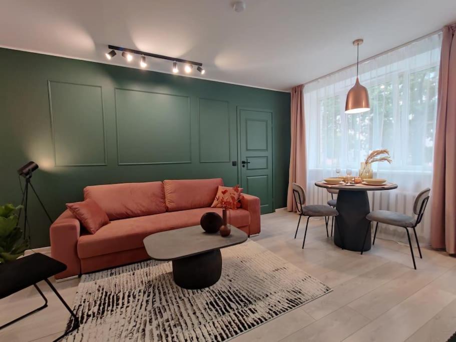 een woonkamer met een bank en een tafel bij Super asukohas modernne korter! in Pärnu