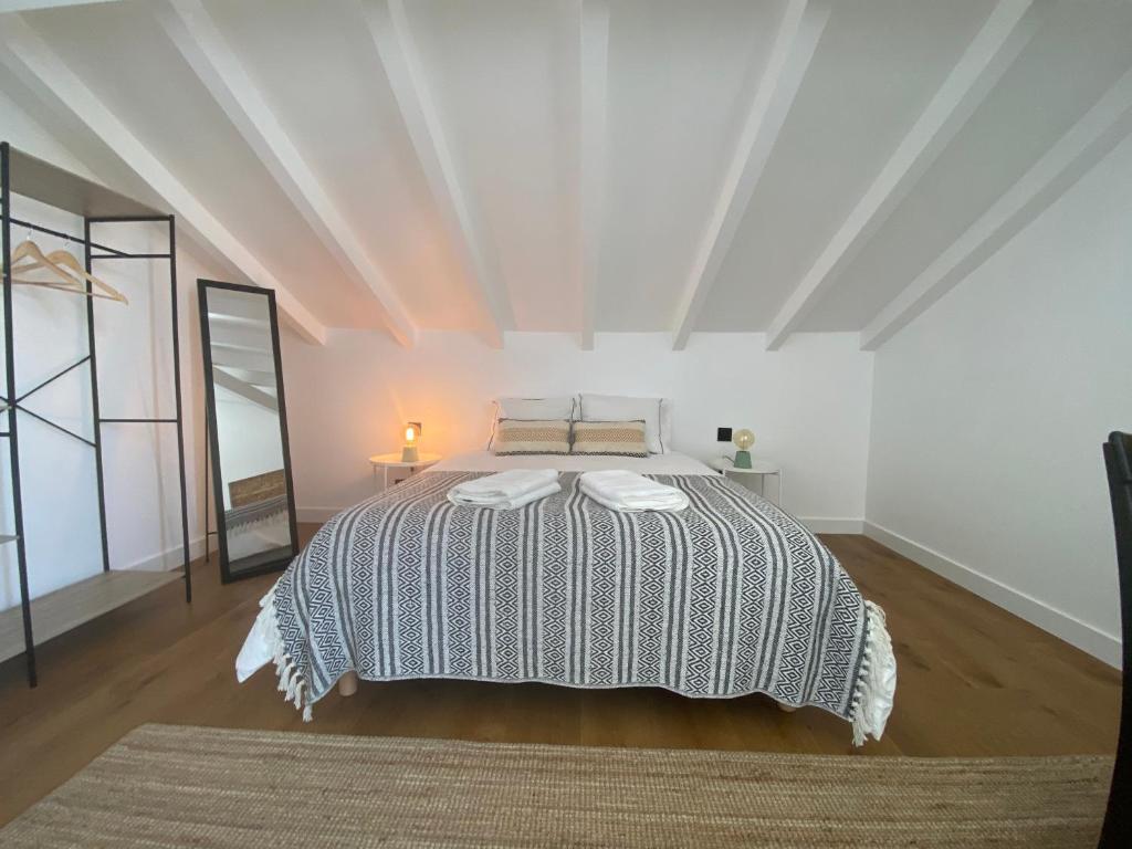 グランドラにあるGrândola Suites - Suite Loftの白い部屋に大型ベッド1台が備わるベッドルーム1室が備わります。