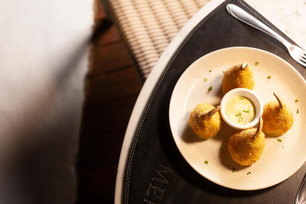 a plate of food with dipping sauce on a table at Mero Hotel Boutique in Barra Grande