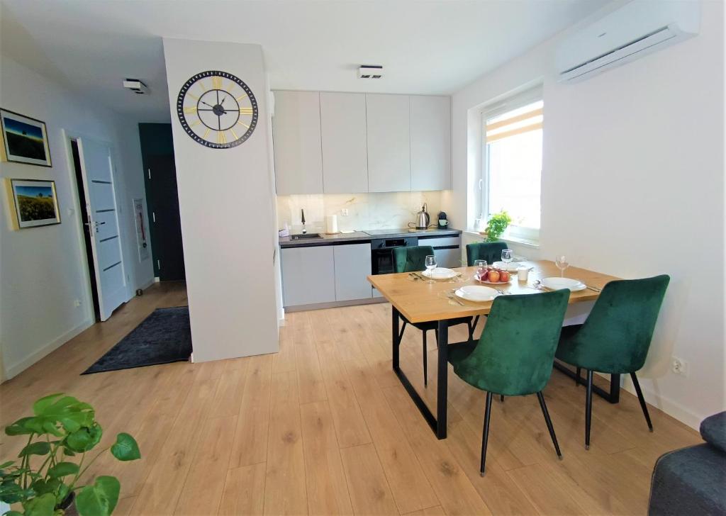 a kitchen and dining room with a table and chairs at Apartament nr15 z parkingiem podziemnym in Toruń