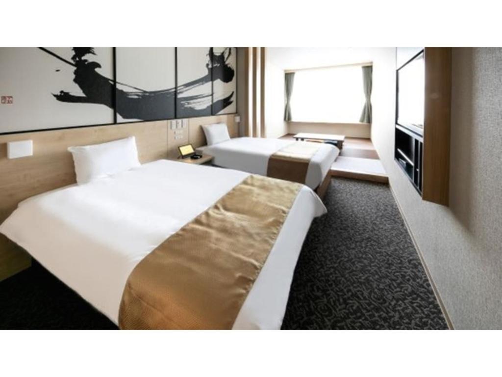 a hotel room with two beds and a tv at Sakishima Cosmo Tower Hotel - Vacation STAY 01075v in Osaka