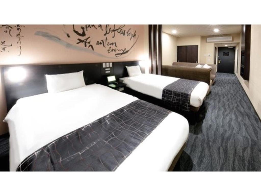 ein Hotelzimmer mit 2 Betten und einem Sofa in der Unterkunft Sakishima Cosmo Tower Hotel - Vacation STAY 01080v in Osaka