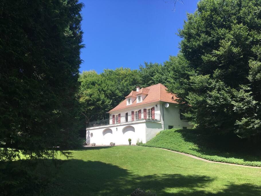 una casa blanca con techo rojo en un césped verde en La Claperie, familial, parc et piscine, en Brantôme