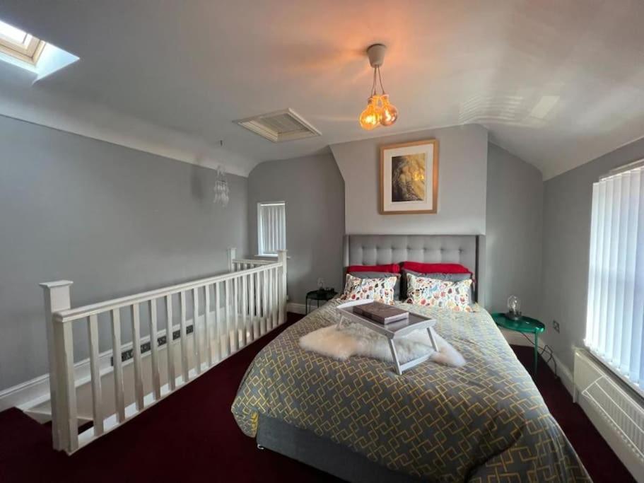 een slaapkamer met een bed met rode kussens bij The Townhouse in Waterloo sleeps 4 in Waterloo