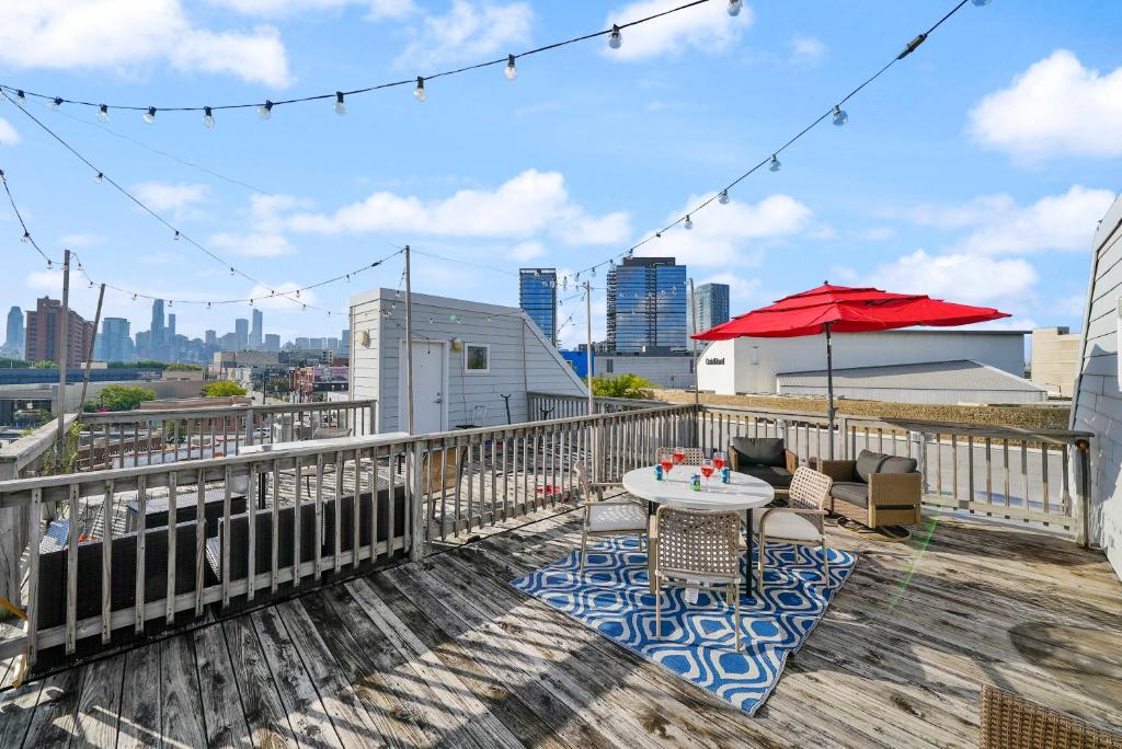 a patio with a table and a red umbrella on a roof at City-View Chicago 3-BR Rooftop in Chicago