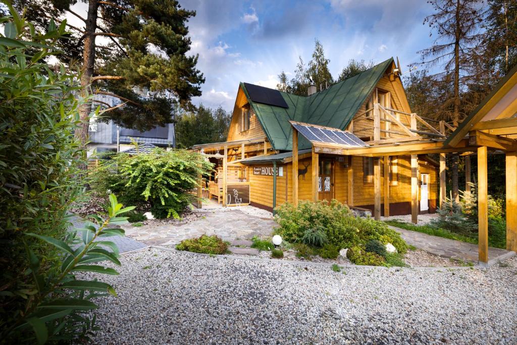 une maison en rondins avec un toit vert dans l'établissement Chalet Green Park, à Stará Lesná