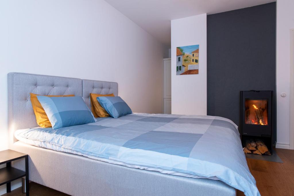 a bedroom with a large bed and a fireplace at Cozy apt AC Free Wi-Fi Self Check-In near Beach in Pärnu